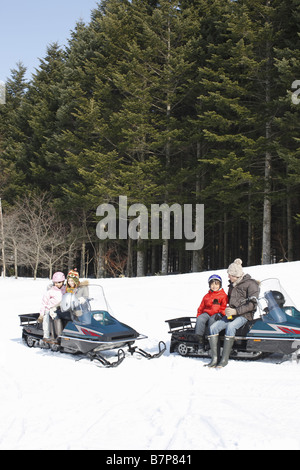 Famiglia a cavallo su motoslitte Foto Stock