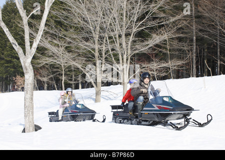 Famiglia a cavallo su motoslitte Foto Stock