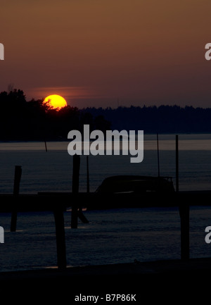 Bel tramonto con un piccolo porto in primo piano Foto Stock