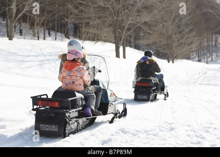 Famiglia a cavallo su motoslitte Foto Stock