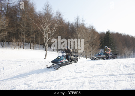 Famiglia a cavallo su motoslitte Foto Stock