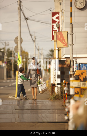 La madre e il bambino sul loro modo home Foto Stock