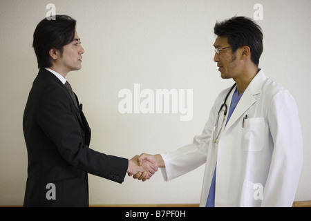Imprenditore e medico stringono le mani Foto Stock