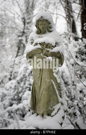 Angelo statua sotto la neve nel cimitero di Nunhead Foto Stock