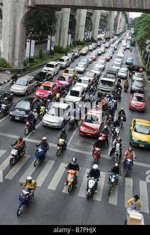 Scooters ottenere un inizio capo al semaforo in pesanti congestiion Pathumwan quartiere centrale di Bangkok in Thailandia Foto Stock