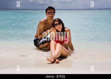 Una giovane coppia su una spiaggia delle Maldive Foto Stock