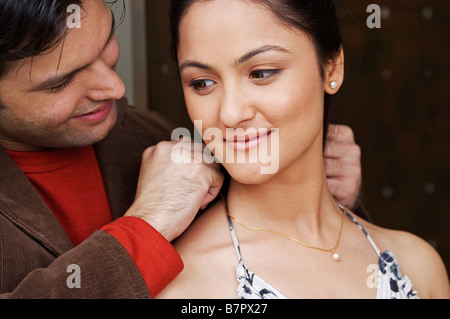 Uomo collana mettendo sulla donna di collo Foto Stock