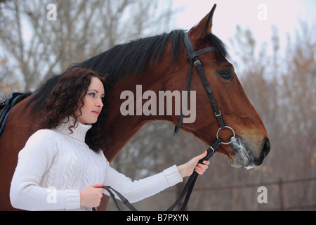 Una giovane ragazza appoggiata al suo cavallo a un evento equestre Foto Stock