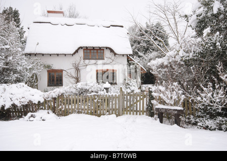 Cottage con tetto in paglia in snow Foto Stock