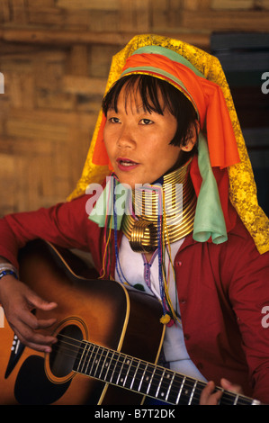 Ritratto di birmani a collo lungo Padaung Kayan (o) Karenni donna a suonare la chitarra in un campo di rifugiati, Mae Hong Son provincia della Thailandia Foto Stock