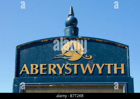 Il cartello di Aberystwyth, illuminato dal sole, si contrappone a un Galles con cielo blu Foto Stock