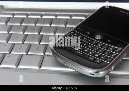 Smartphone Blackberry sulla tastiera del computer Foto Stock