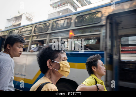 Donna che indossa la maschera per il viso contro il traffico pesante inquinamento atmosferico Chinatown quartiere centrale di Bangkok in Thailandia Foto Stock