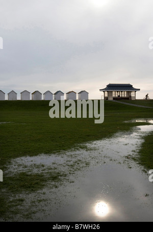 Spiaggia di capanne, Sun e il pavilion, riflessa nell'acqua di allagamento Foto Stock