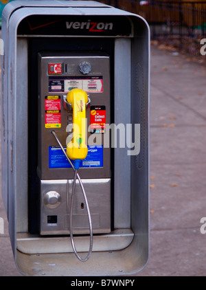 Sporco e colorati di pagare telefono alla ricerca di vecchio stile in un moderno impianto urbanistico. Foto Stock