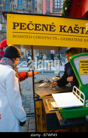 Persone che acquistano le caldarroste durante il mercatino di Natale in piazza della città vecchia di Praga Repubblica Ceca Europa Foto Stock