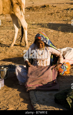 Una vecchia donna di Rajasthani si prepara per la lunga giornata di Nagaur fiera del bestiame nel Rajasthan, India. Foto Stock