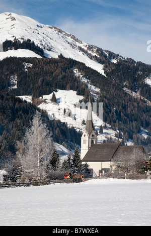 Rauris Austria villaggio alpino e chiesa parrocchiale nelle Alpi austriache con neve in Rauriser Sonnen Valley in inverno Foto Stock