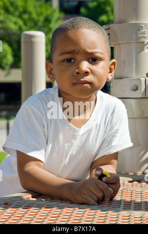 Americano africano bambino maschio di 4 anni a suonare in un parco giochi pubblico Foto Stock