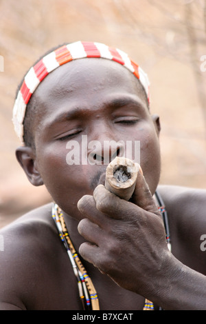 Africa Tanzania Lago Eyasi Hadzabe uomo fumo da un tradizionale tubo di argilla Foto Stock