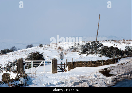Il vecchio palo di legno un marcatore per la brughiera viaggiatori nella neve sul Longshaw Station Wagon nel Derbyshire "Gran Bretagna" Foto Stock