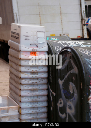 Plastica ondulata contenitori impilati accanto alla mail di due scatole di stoccaggio coperto di graffiti sul marciapiede in New York City. Foto Stock