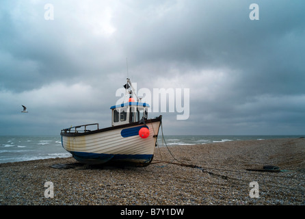 Una barca da pesca redatto su di una spiaggia di ciottoli sull'Inghilterra costa di canale Foto Stock