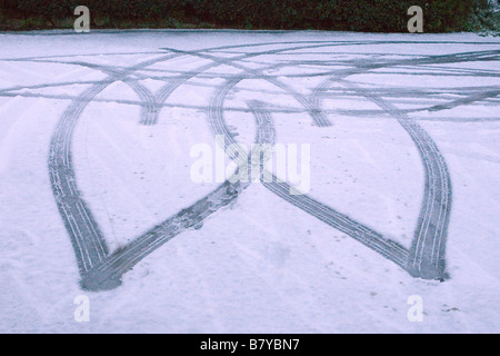 Due cuori incisi nella neve dalle piste dei pneumatici Foto Stock