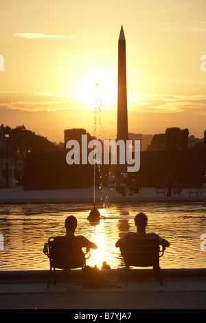 Due persone che godono di un estate tramonto al Jardin des Tuileries rivolta verso la Place de la Concorde, Paris, Francia Foto Stock