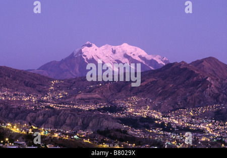 Luci dei sobborghi della zona Sur della città e del Monte Illimani al tramonto, la Paz, Bolivia Foto Stock