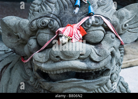 Custode cinese lion con un nastro rosso e la campana, Penang Foto Stock