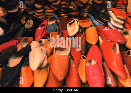 Pile di pelli backless pantofola scarpe, o babouches, in vendita su uno stallo nella medina di Fes el-Bali, Fez, in Marocco. Foto Stock