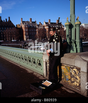 L'uomo gioca la cornamusa sul Westminster Bridge London Inghilterra England Regno Unito Foto Stock