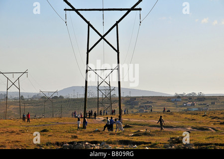 Linee di trasmissione di energia elettrica marzo attraverso il paesaggio nelle township di Grahamstown, Sud Africa Foto Stock