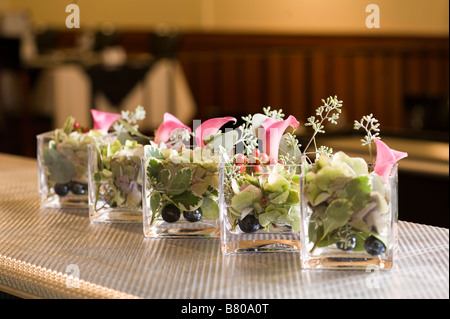 Piccoli vasi di vetro tenendo un bellissimo allestimento floreale. Foto Stock
