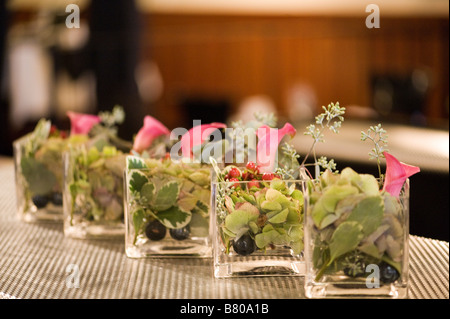Piccoli vasi di vetro tenendo un bellissimo allestimento floreale. Foto Stock