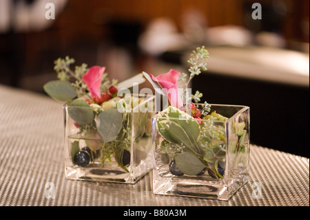 Piccoli vasi di vetro tenendo un bellissimo allestimento floreale. Foto Stock