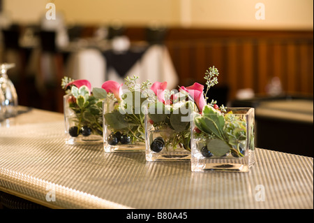 Piccoli vasi di vetro tenendo un bellissimo allestimento floreale. Foto Stock