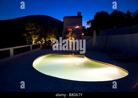 In una piscina a forma di rene di notte in vacanza Foto Stock