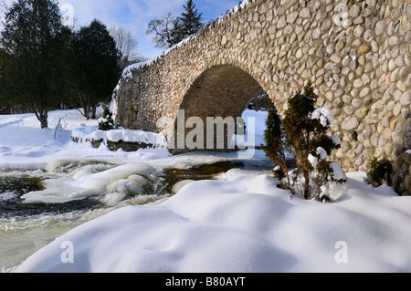 Spencer Creek in esecuzione sotto un ponte in pietra a Webster cade Conservation Area Parco in inverno Foto Stock