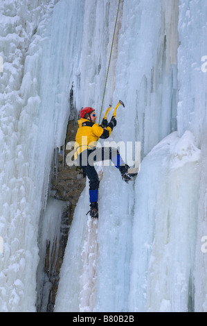 Ice Climber parte anteriore rivolta verso l'alto una ripida cascata di ghiaccio con corda superiore sosta a Tiffany Falls Ontario Foto Stock