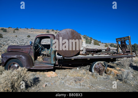 Un vecchio carrello arrugginito con un serbatoio in esso s bed si trova lungo un lato della collina a sud di Virginia City Nevada Foto Stock