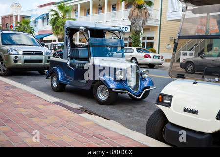 Carrelli da golf parcheggiate lungo la strada principale nei villaggi la comunità di pensione nella Florida Centrale, STATI UNITI D'AMERICA Foto Stock