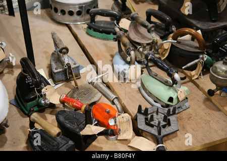 Raccolta di gas powered ferri da stiro su un tavolo/banco in un museo Foto Stock