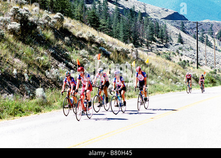 Un gruppo di ciclisti in bicicletta in salita su una strada lastricata nelle montagne della Columbia britannica in Canada Foto Stock