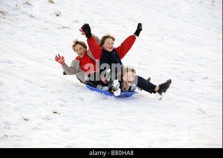 Ragazzi in slitta nella neve Telford Inghilterra Shropshire Gran Bretagna UK inverno 2009 riproduzione divertente FOTO DI DAVID BAGNALL Foto Stock