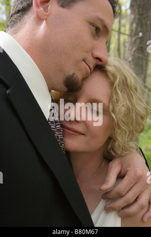 Primo piano della sposa e lo sposo abbracciando dopo la cerimonia di nozze Foto Stock