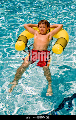 A dieci anni di vecchio ragazzo galleggia in una piscina a Laguna Niguel CA Foto Stock