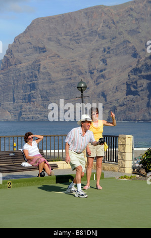 I turisti si vede durante un gioco di bocce a Los Gigantes Tenerife Isole Canarie in background le famose Scogliere Foto Stock