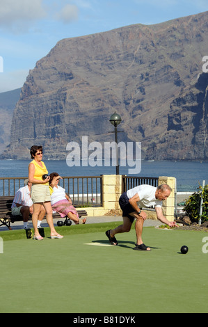 I turisti si vede durante un gioco di bocce a Los Gigantes Tenerife Isole Canarie in background le famose Scogliere Foto Stock